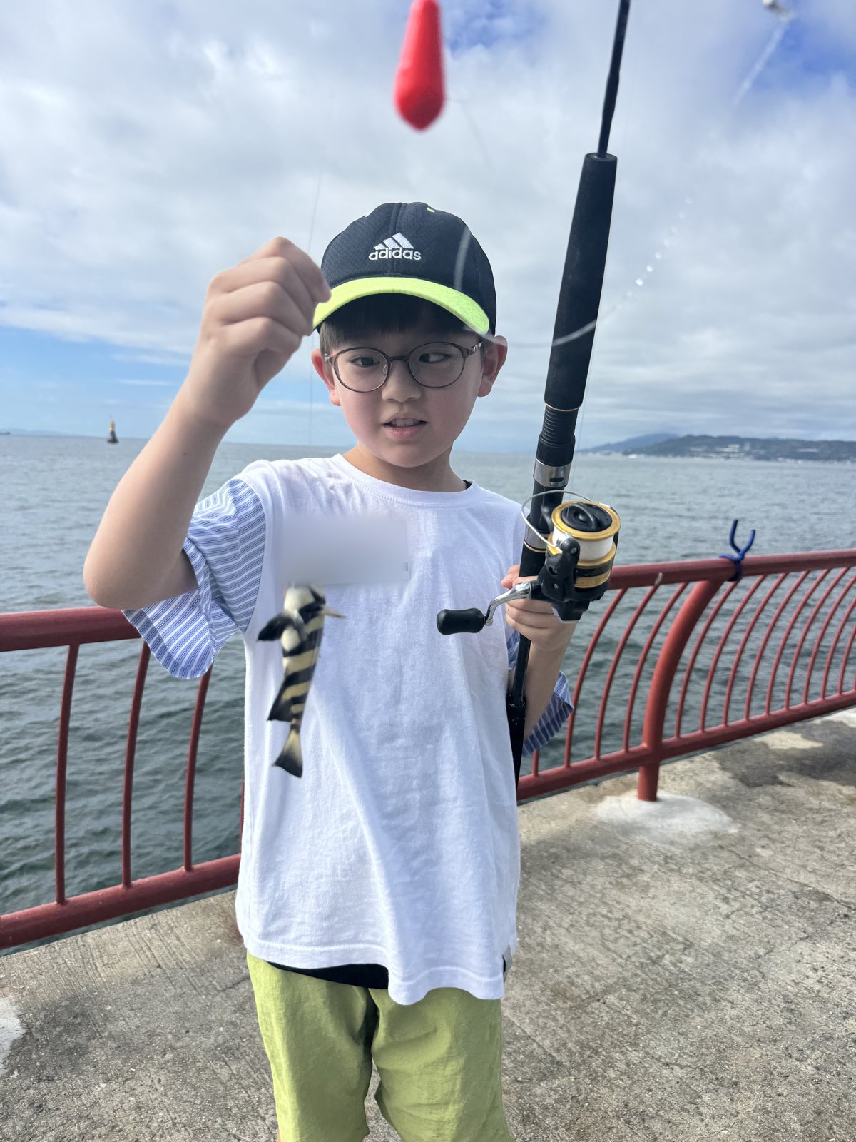 自分で釣った魚を見せるお子さま