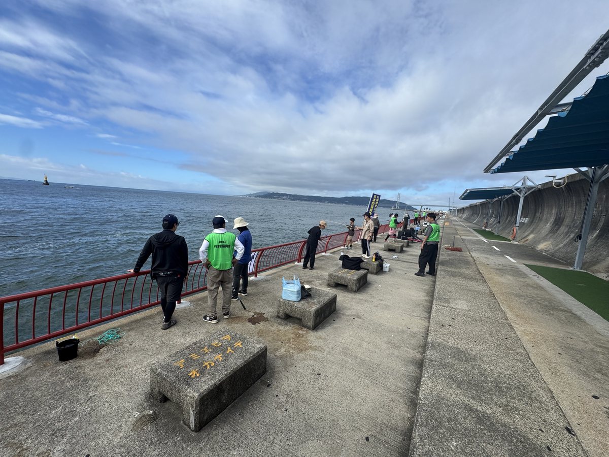 平磯海づり公園の釣り場に並んで釣りをする参加者と指導員