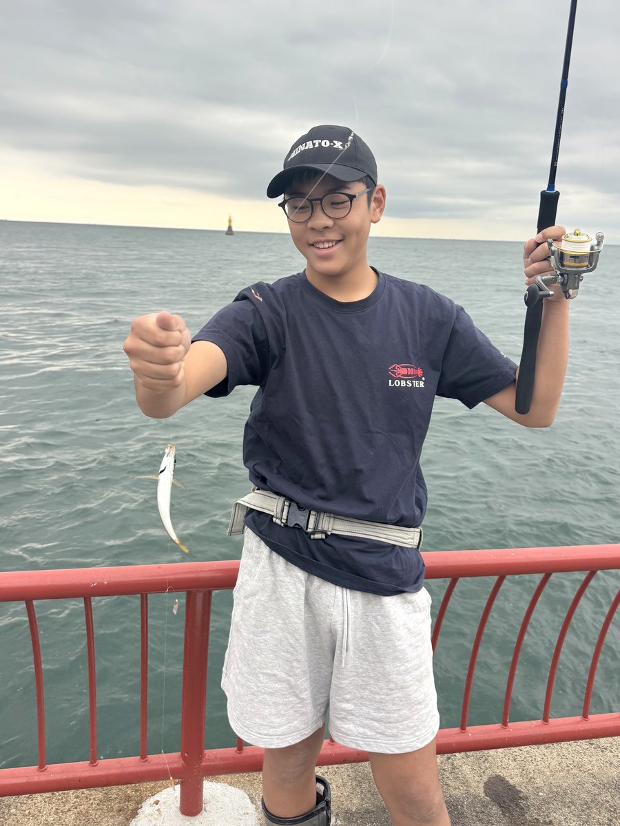 釣れたアジを見せる部員