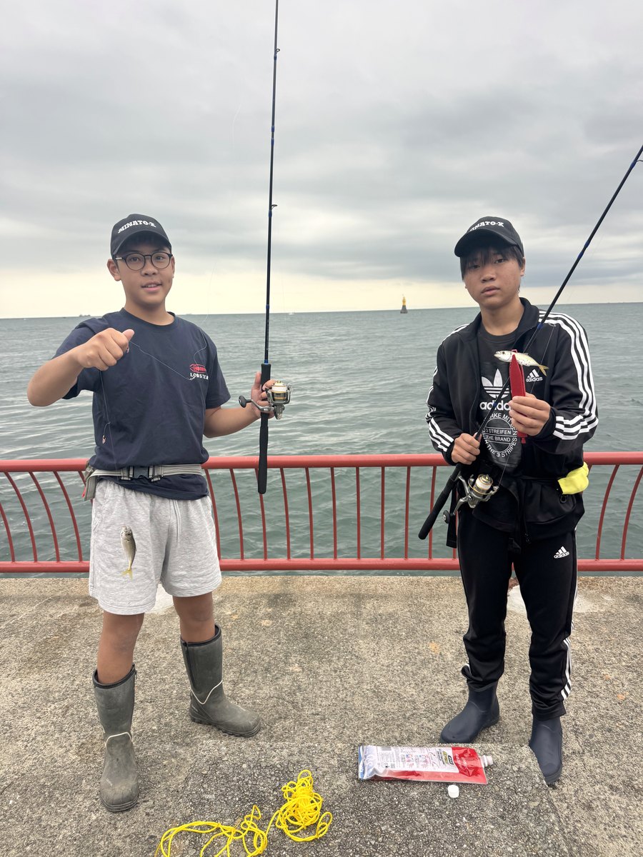 アジを釣り上げて並ぶ部員2人