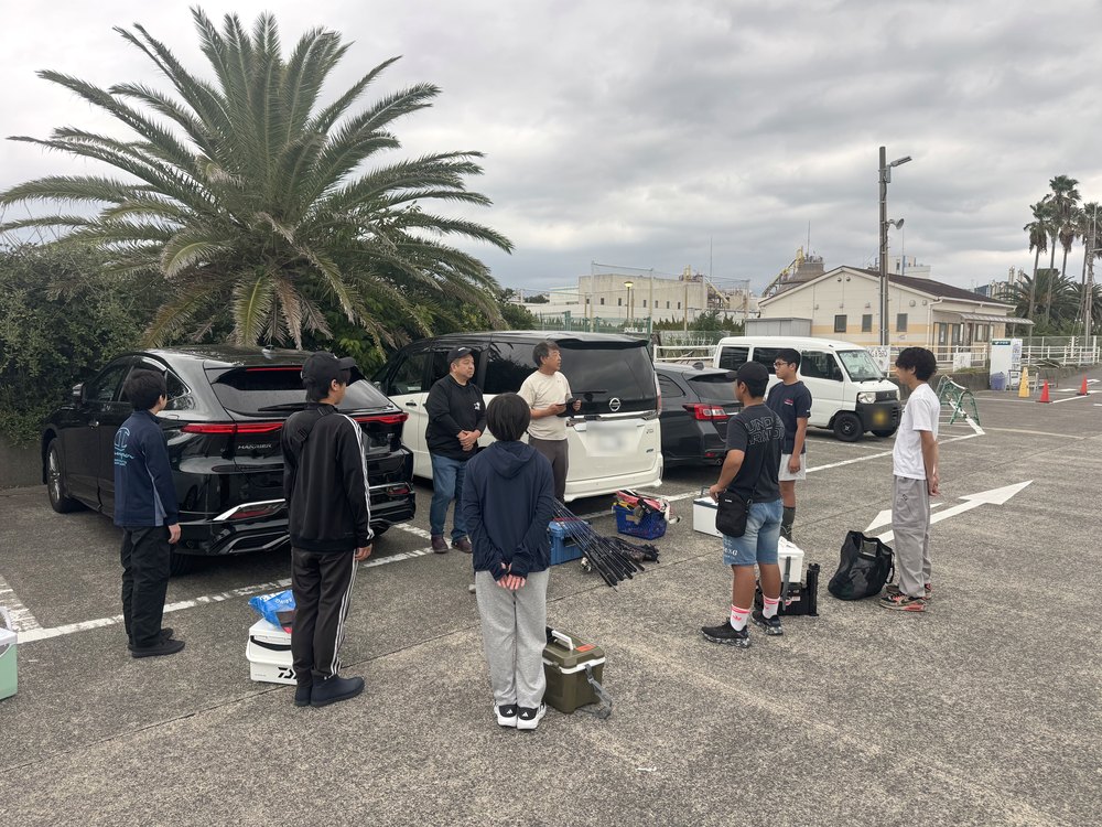 駐車場で朝礼をするナビゲーターと部員