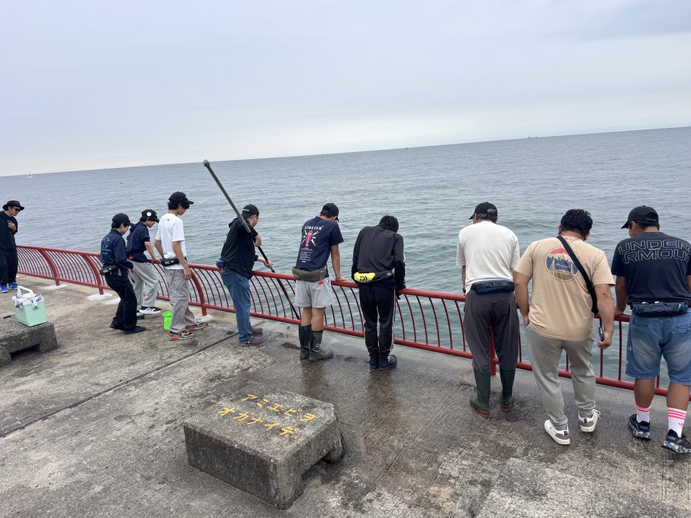 手すりに並んで海をのぞきこむ部員とナビゲーター