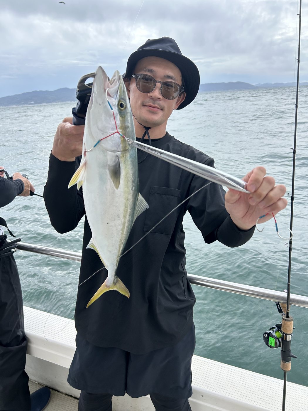 ジグと釣り上げた青物を見せる参加者