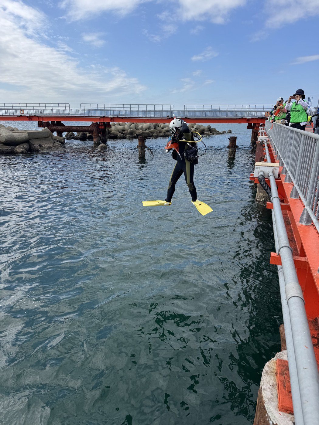 釣り台から海へ入るダイバー