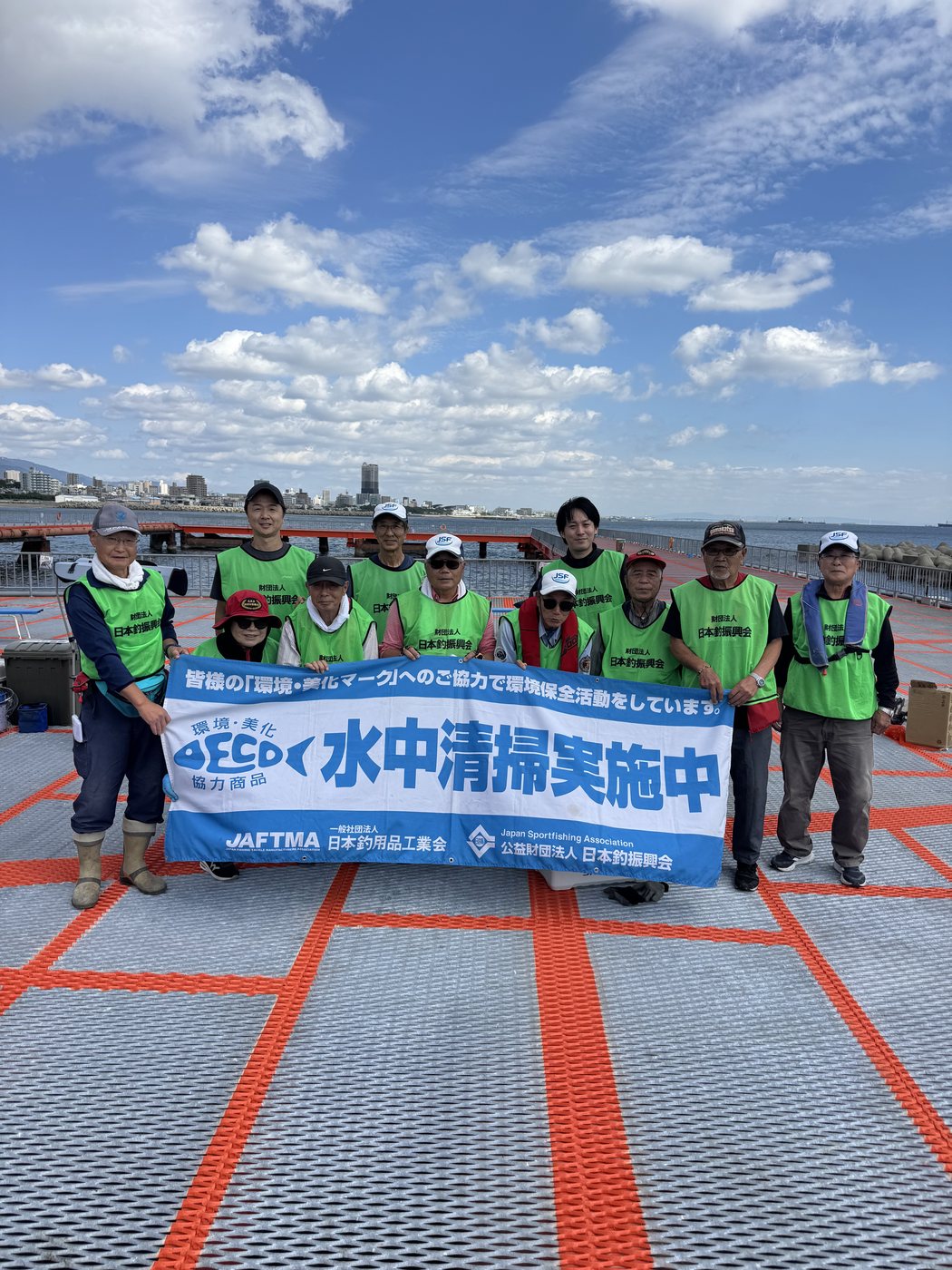 「水中清掃実施中」の横断幕を持つ参加者の皆さん