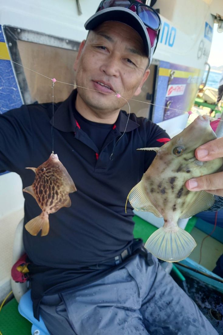 両手にカワハギを持つ参加者
